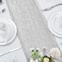 Chemin de Table Argenté Décoratif à Paillettes sur une table blanche à côté de deux assiettes