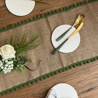 Chemin de Table en Jute Style Rétro avec Frange sur une table avec des couverts, des assiettes et des fleurs