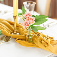 Chemin de Table en Tissu Jaune Fait Main sur une table avec des roses, des bougies, des cuillères et un verre