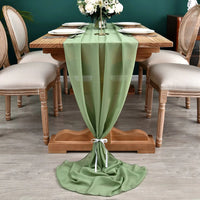 Chemin de Table Vert Gracieux et Robuste sur une table en bois avec des assiettes, des couverts et des fleurs