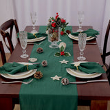 Chemin de Table Vert de Noël Doux et Durable sur une table en bois avec des assiettes, des couverts, des verres et de la décoration