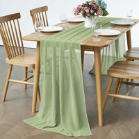 Chemin de Table Vert Pratique et Élégant sur une table en bois avec des assiettes, des verres, des couverts et des fleurs