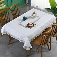 Nappe Blanche Douce et Imperméable sur une table avec une assiette, des couverts, une théière et des fleurs