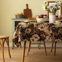 Nappe Coton Rectangulaire et Élégante avec Motif Floral, de couleur noire, dans une salle à manger avce des chaises en bois.