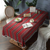 Nappe Coton Rouge Imperméable avec Pompons, avec motifs géométriques, dans une salle à manger vintage.