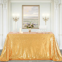 Nappe Doree Élégante à Paillettes, dans une sorte de salle de reception blanche, sur une table rectangulaire.