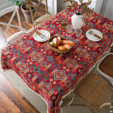 Nappe Rouge Décorative à Motif Tendance sur une table avec des assiettes, des couverts, un panier, des verres et des fleurs