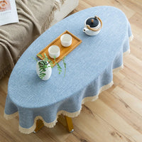 Nappe Table Ovale Bleue Discrète et Tendance sur une table avec des tasses et des fleurs et un canapé à côté