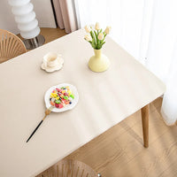 Sous Nappe Beige et Rectangulaire en Simili Cuir sur une table en bois avec des fleurs, une assiette, une fourchette et une tasse