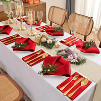 table dressée avec serviettes rouge et couverts dorés 